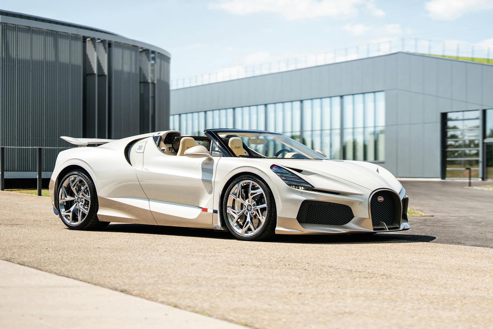 Bugatti W16 Mistral blanche vue de trois quarts avant, derni&egrave;re voiture &eacute;quip&eacute;e du moteur W16, gar&eacute;e devant un b&acirc;timent industriel