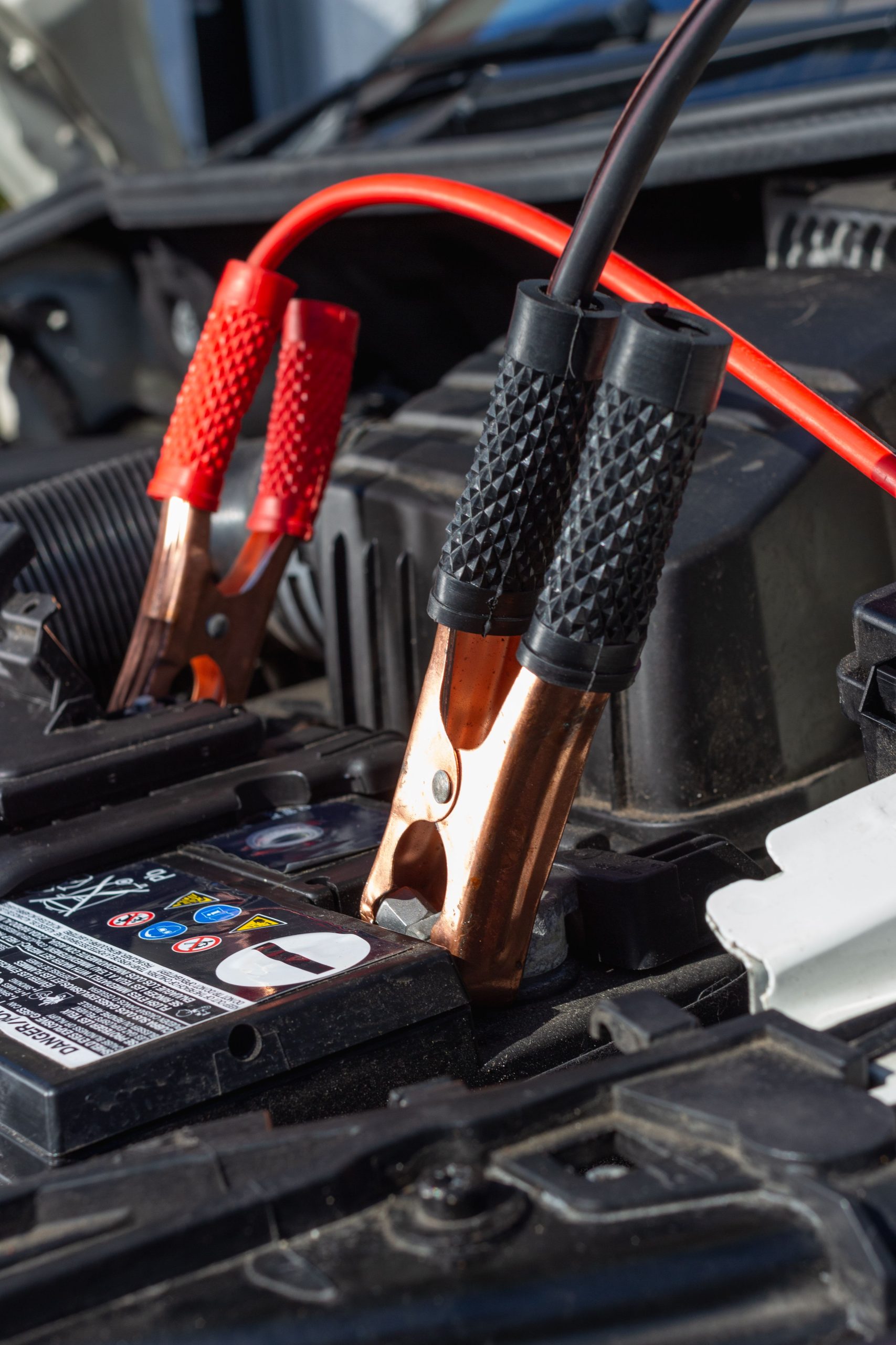 Pinces de d&eacute;marrage rouges connect&eacute;es &agrave; une batterie de voiture