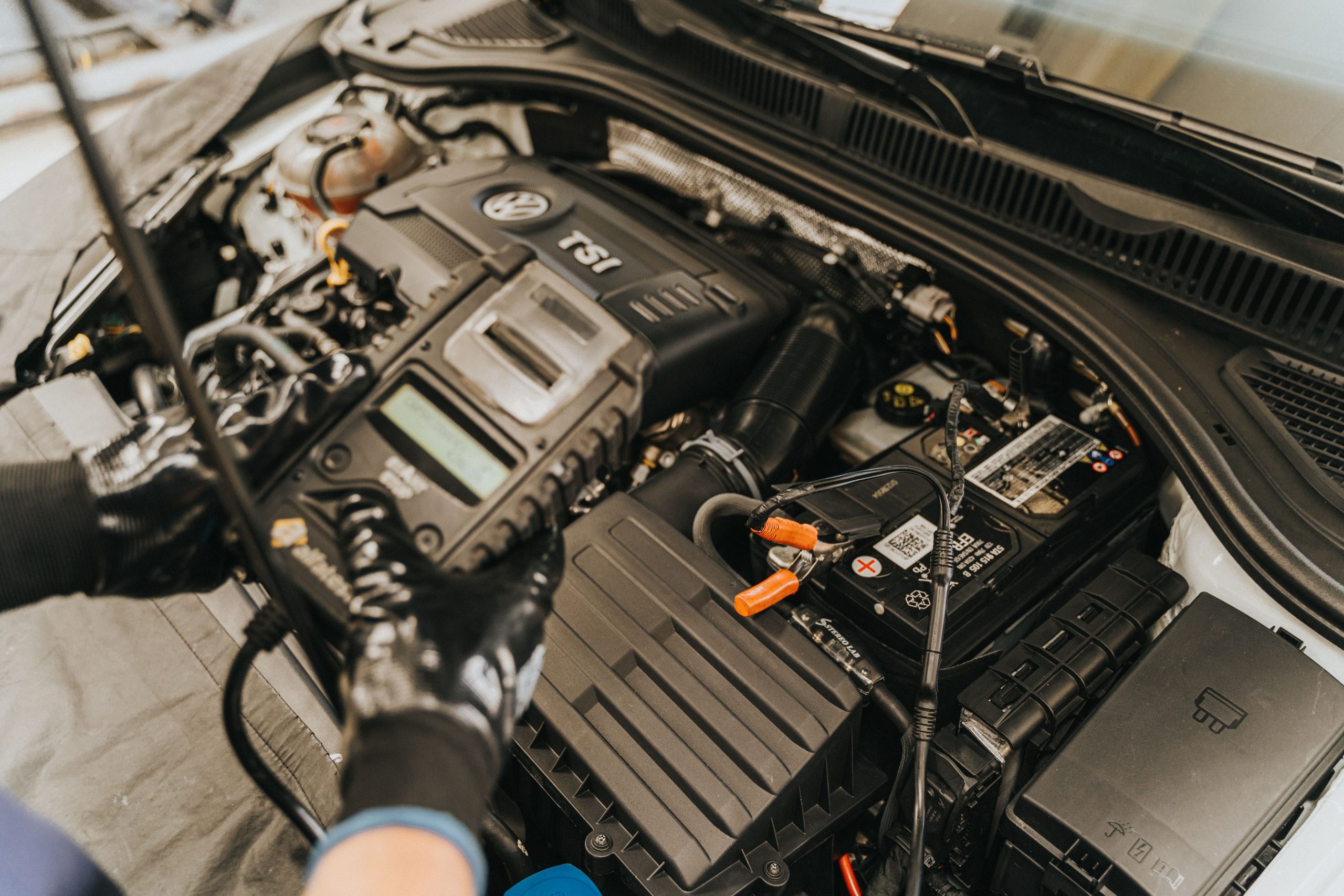 M&eacute;canicien utilisant un appareil de diagnostic sur le moteur d'une voiture
