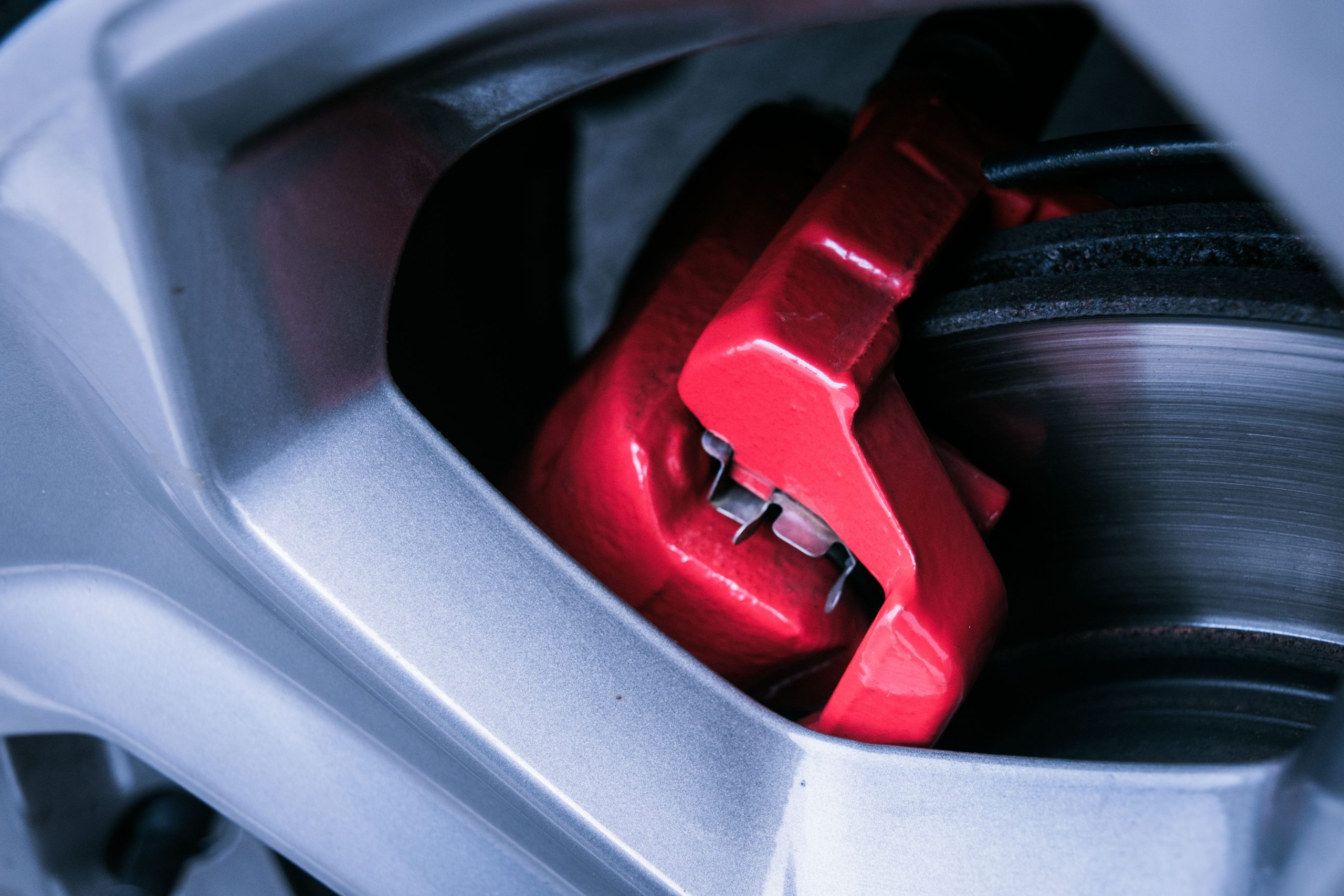 Gros plan sur un &eacute;trier de frein rouge et un disque de frein de voiture