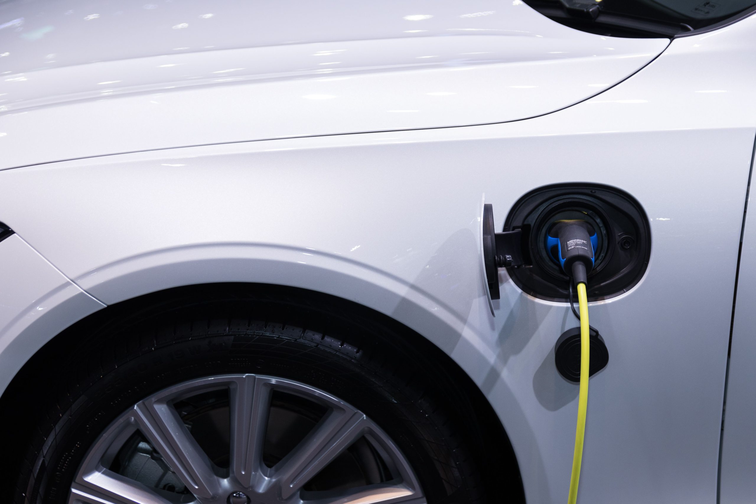 Voiture &eacute;lectrique blanche branch&eacute;e avec vue rapproch&eacute;e du port de recharge